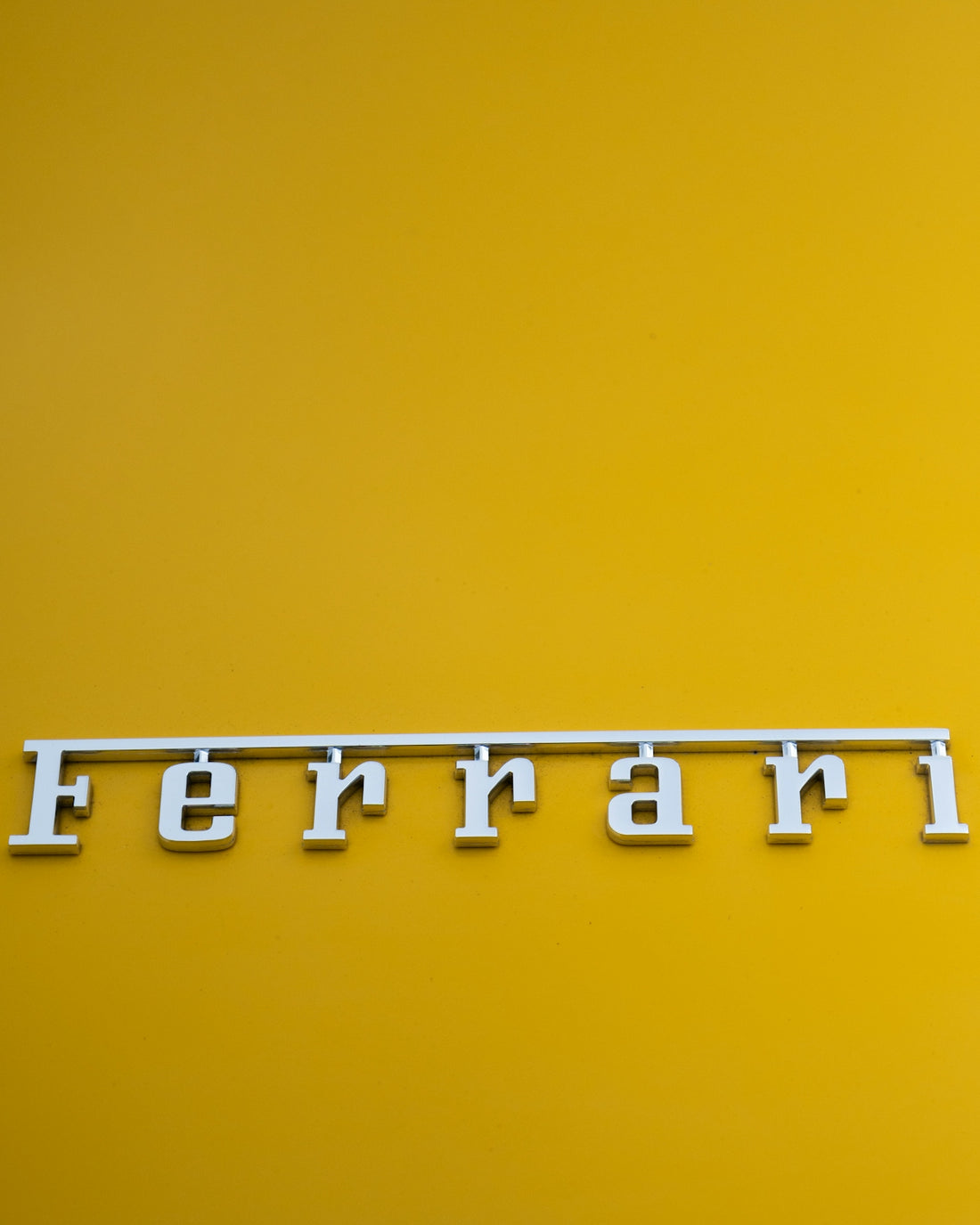 a close up of the word ferrari on a yellow background
