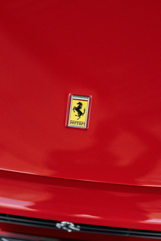 a ferrari badge on the front of a red car