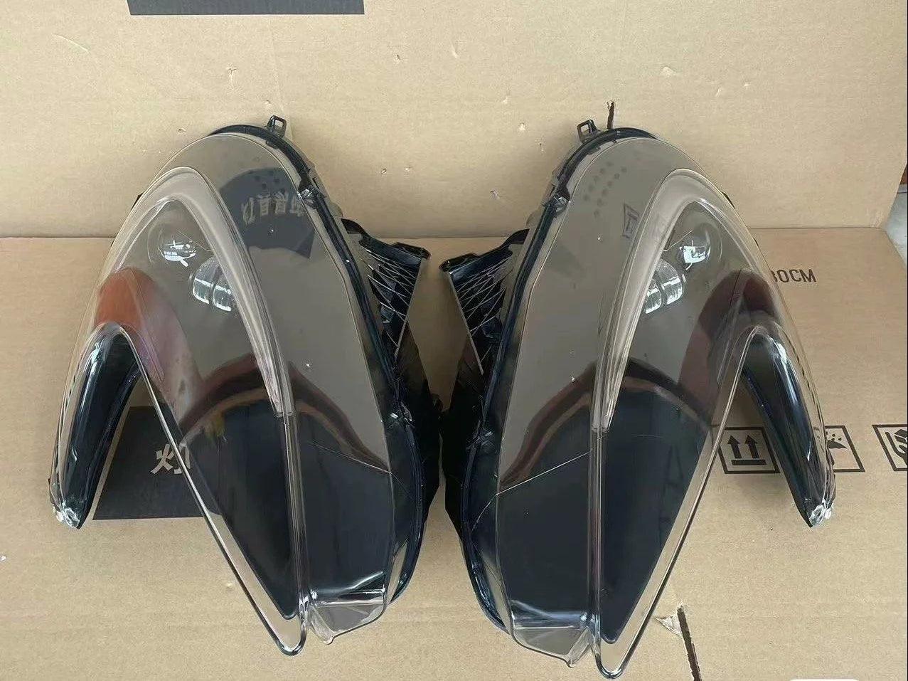Pair of clear plastic headlight covers for exotic sports car on cardboard box