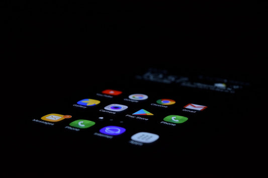 Close-up of a smartphone screen with app icons illuminated in the dark