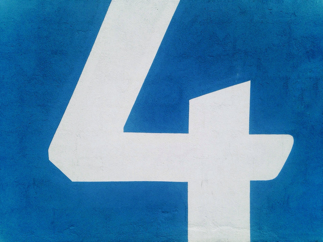 Large white number 4 painted on a blue textured wall, automotive-themed background