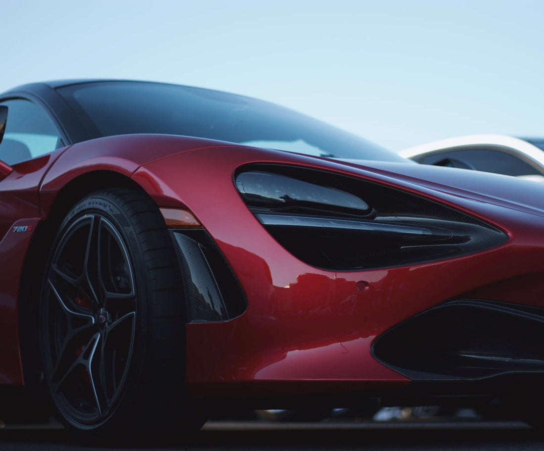 Red McLaren 720S supercar front view with black alloy wheels in daylight