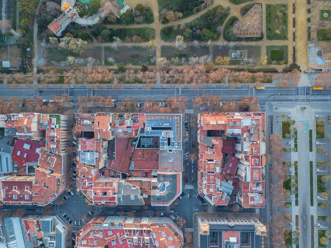 Aerial view of city blocks, streets, and tree-lined park pathways in urban setting