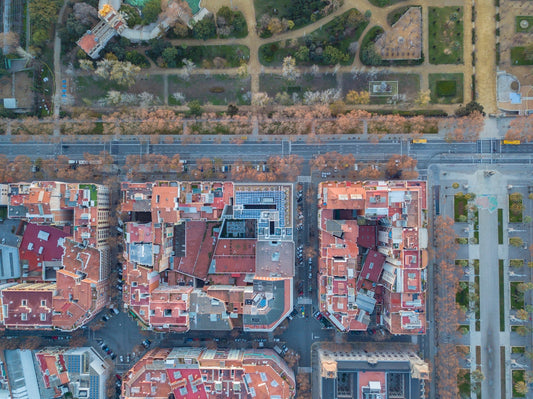Aerial view of city blocks, streets, and tree-lined park pathways in urban setting