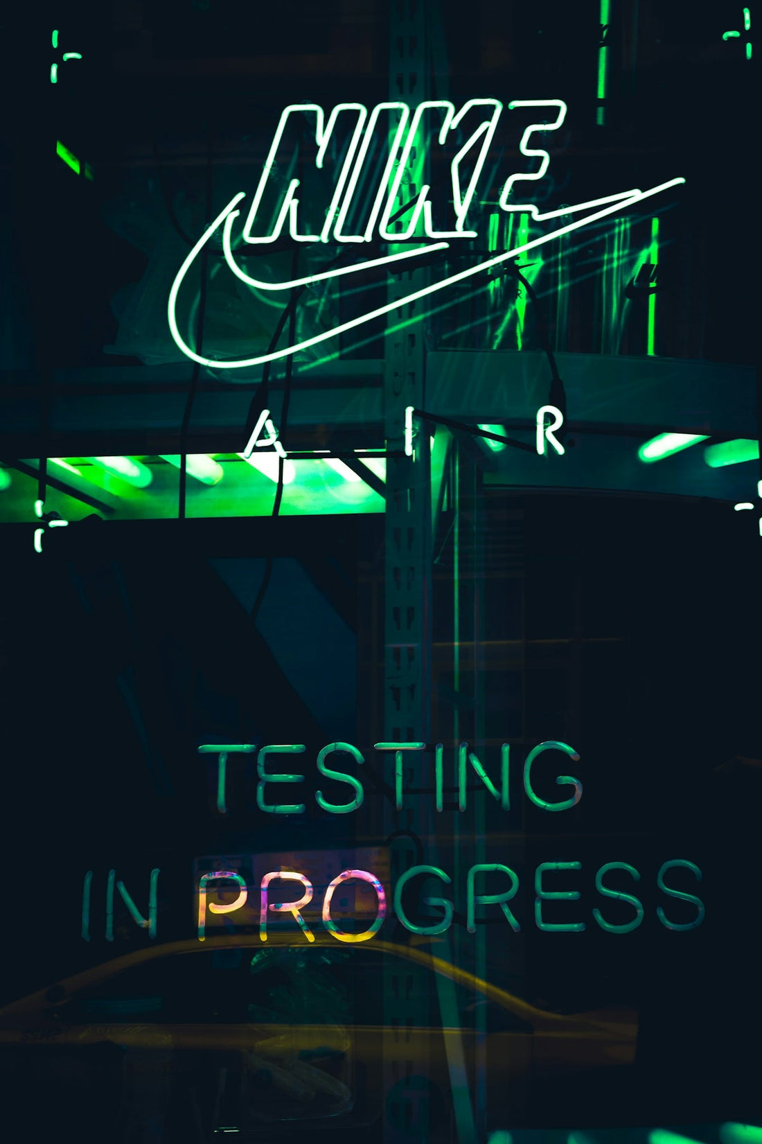 Green neon sign reading 'Nike Air Testing in Progress' with a dark background