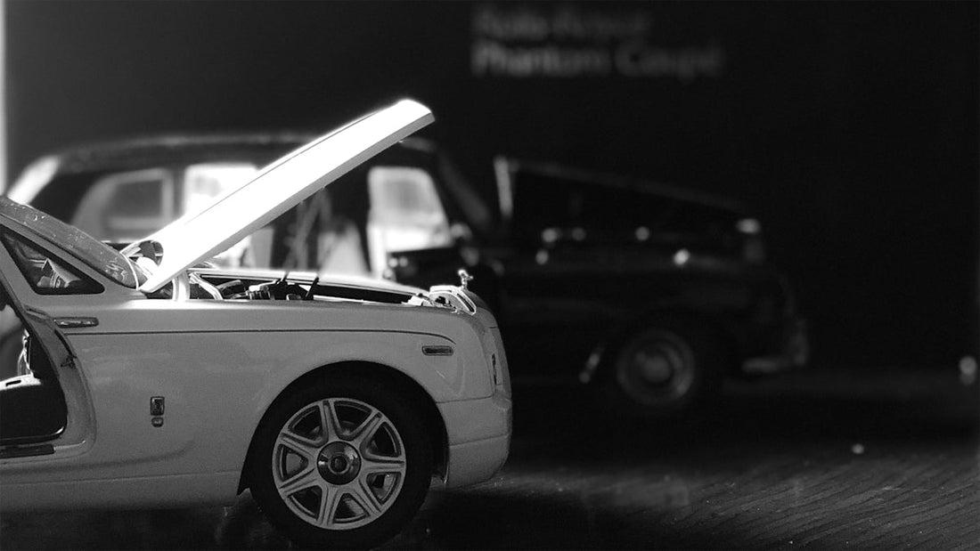 White luxury coupe with hood open, showcasing exotic car design in black and white.