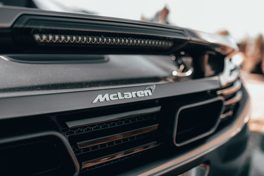 Close-up of McLaren supercar rear badge and grille, luxury exotic car detail