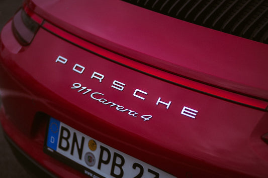 Close-up of red Porsche 911 Carrera 4 rear badge and European license plate