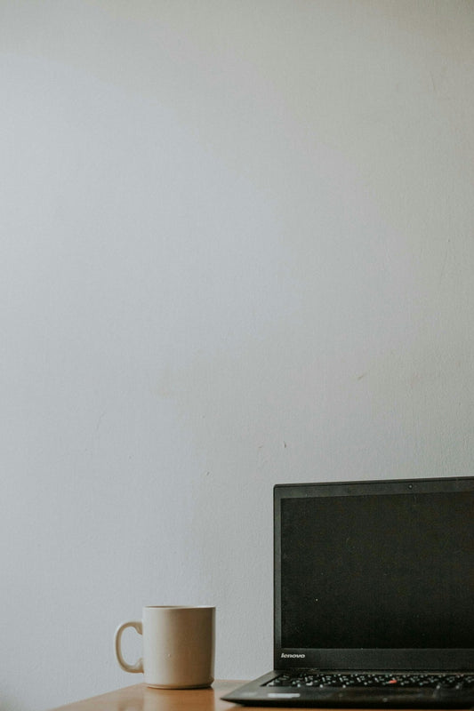 Minimalist workspace with Lenovo laptop and coffee mug on wooden desk
