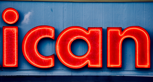 Close-up of red neon letters spelling 'ican' on a blue wall, automotive signage style.