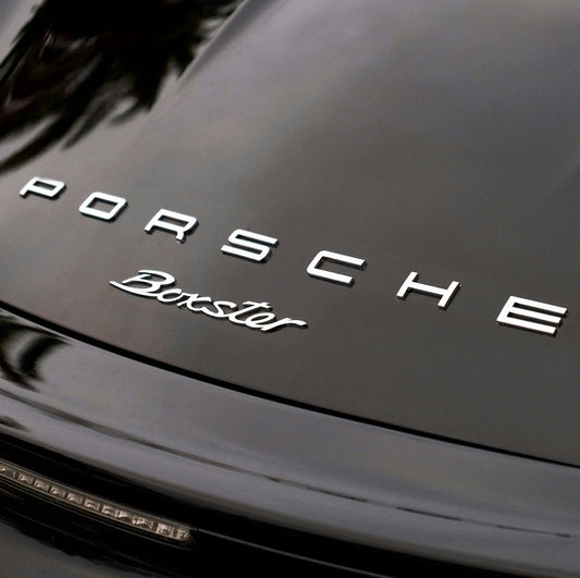 Close-up of Porsche Boxster rear badge on black luxury sports car trunk