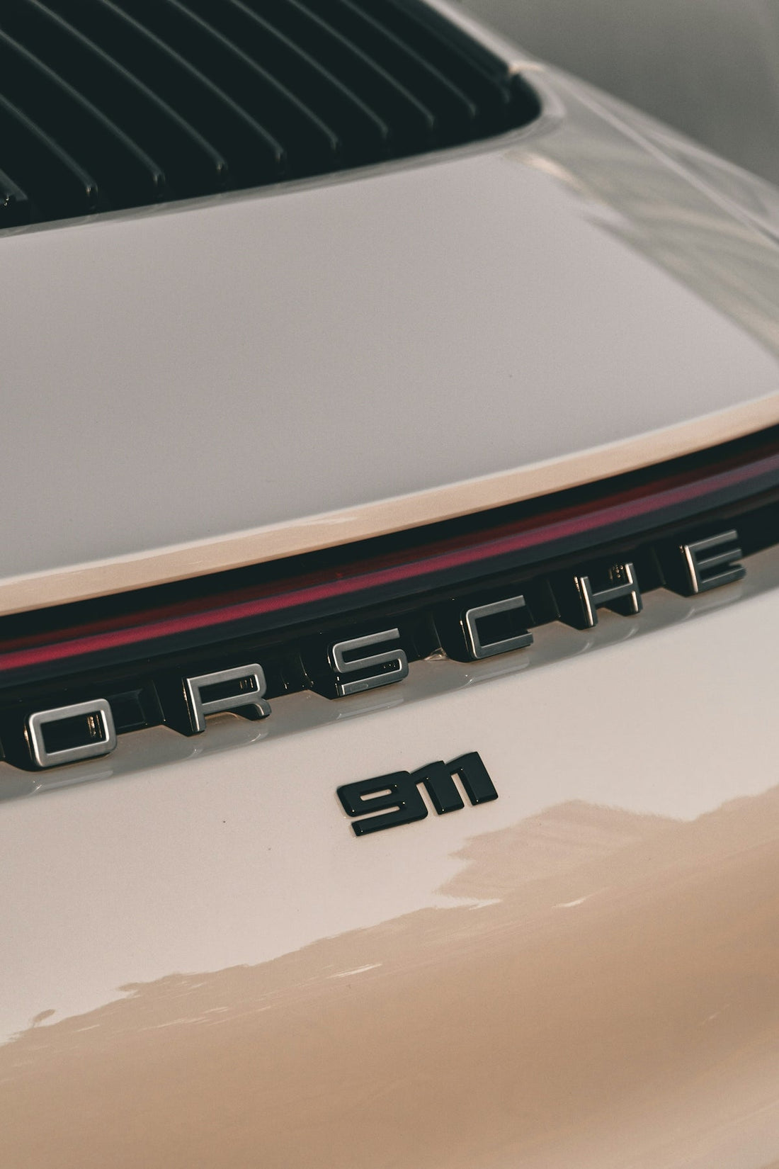 Close-up of a Porsche 911 rear badge and taillight, luxury sports car detail