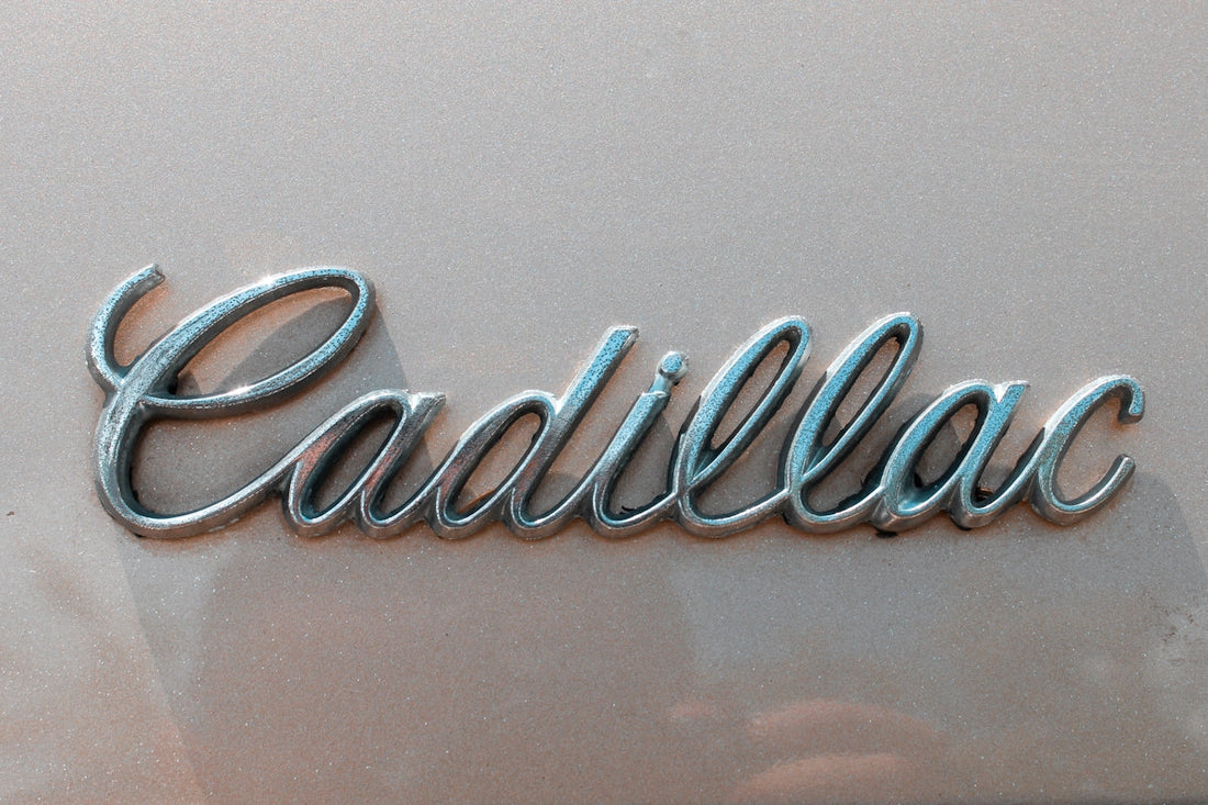 Chrome Cadillac emblem on a beige exotic car hood