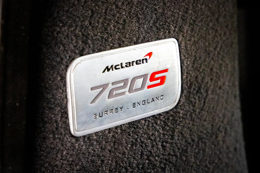 Close-up of McLaren 720S badge on black interior, luxury supercar detail