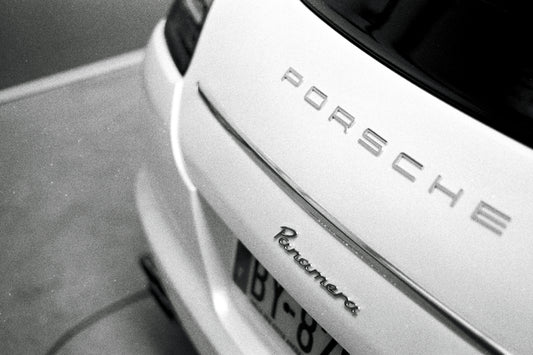 a white porsche car parked in a parking lot