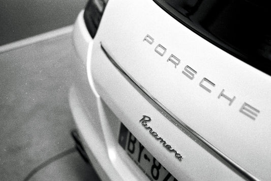 Close-up of rear Porsche Panamera badge on a luxury car in monochrome style