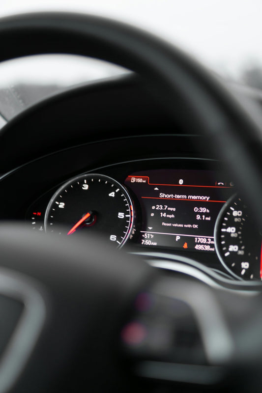 Close-up of a luxury car digital dashboard display with speedometer and performance stats