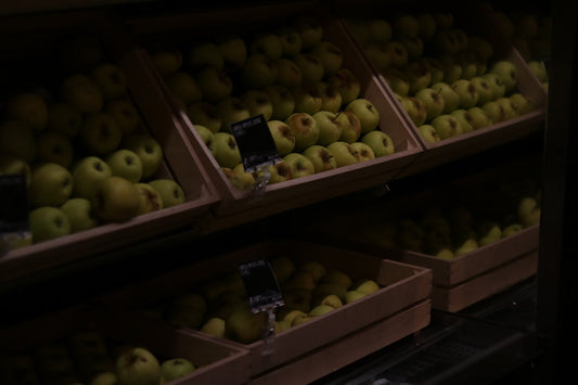wooden crates filled with green apples in supermarket produce section