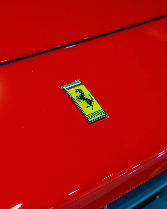 a close up of a red car with a sticker on it