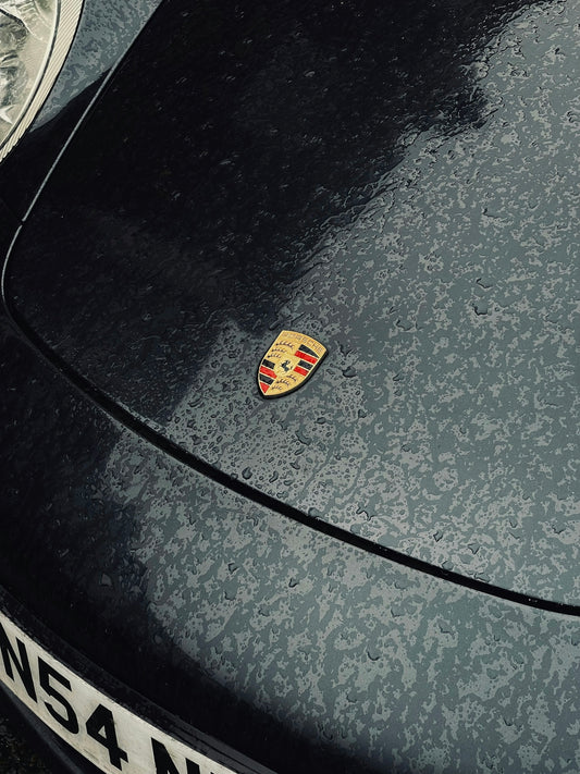 a close up of a porsche logo on the hood of a car
