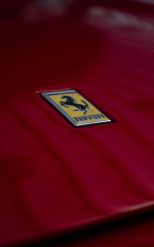 a close up of a ferrari badge on a red car