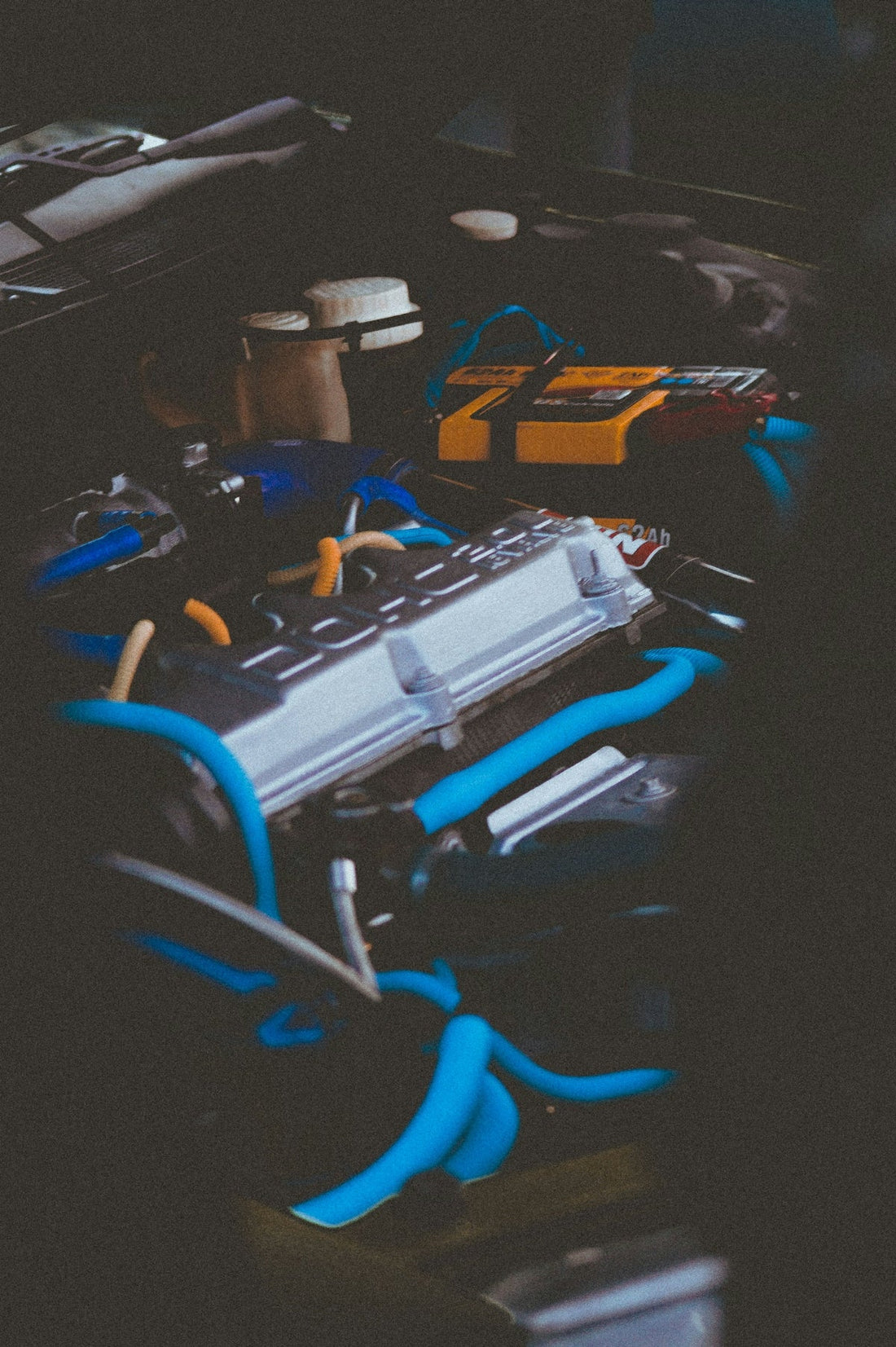 Close-up of a high performance car engine with blue ignition wires and aftermarket parts