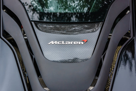 Close-up of McLaren supercar engine cover with carbon fiber detailing