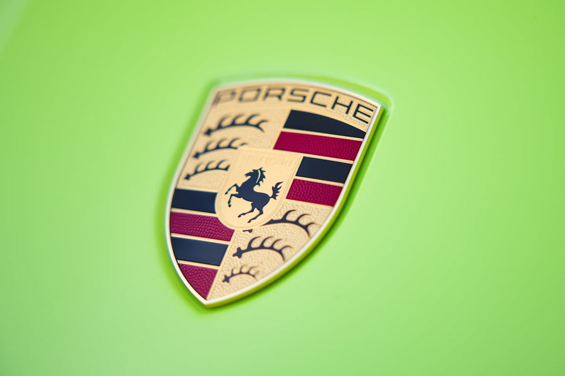 Porsche logo close-up on lime green exotic sports car hood