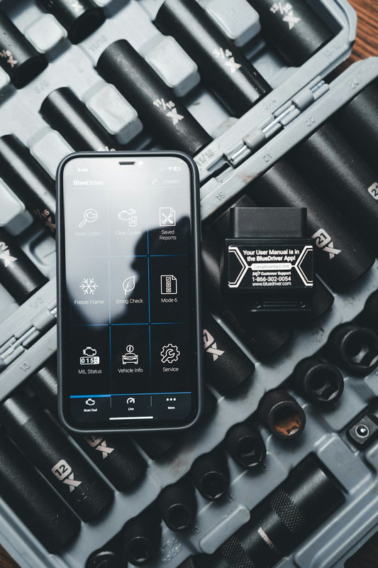 OBD2 diagnostic tool and smartphone with automotive app on a mechanic socket set