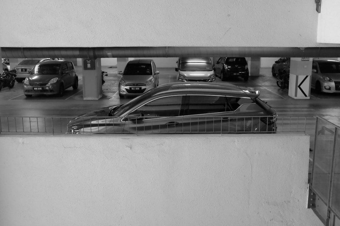 Parked luxury car in black and white parking garage, surrounded by other vehicles