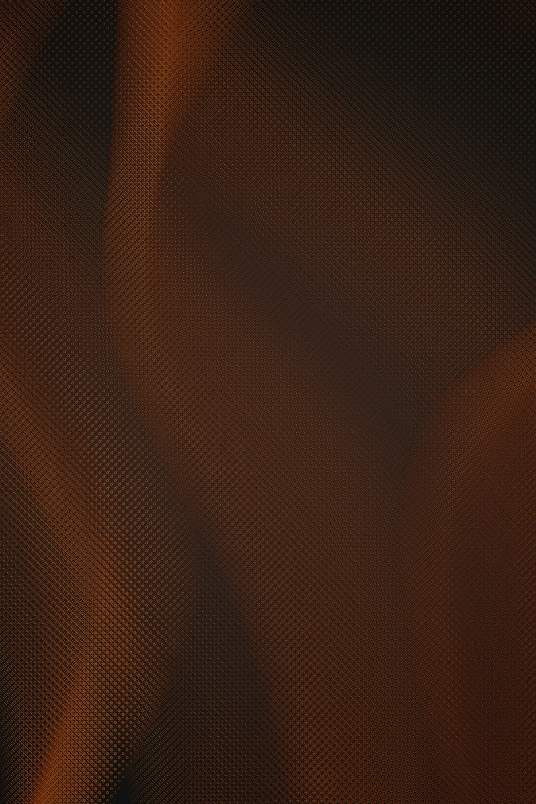 close-up of textured carbon fiber surface with orange-brown lighting
