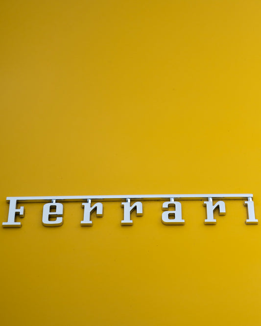 a close up of the word ferrari on a yellow background