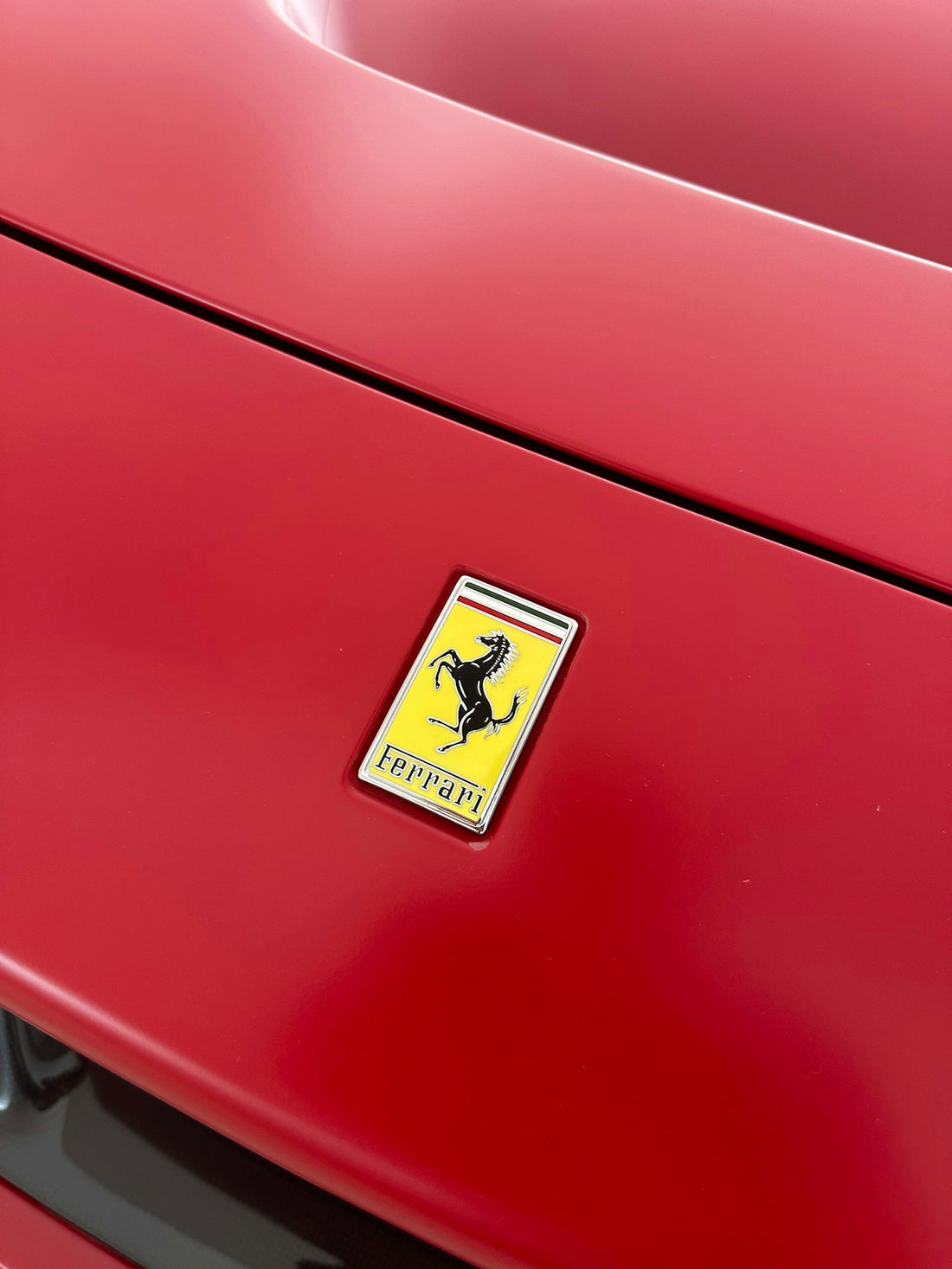 a close up of a red car with a yellow emblem