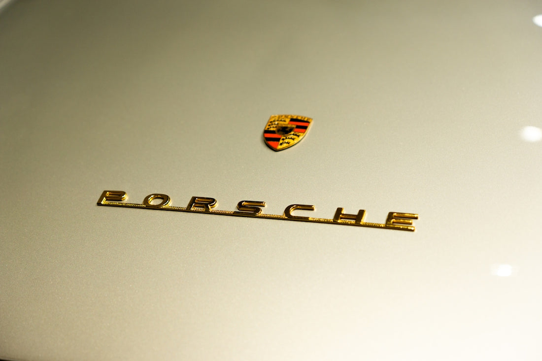 a close up of a porsche emblem on a white car