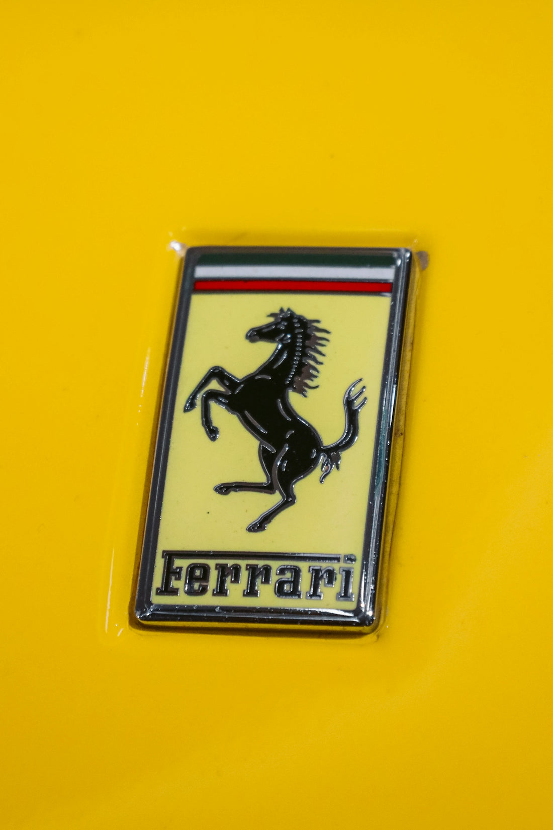 a close up of a ferrari emblem on a yellow car