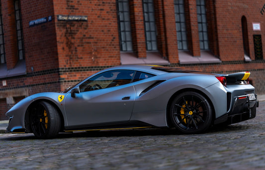 a silver sports car parked in front of a brick building