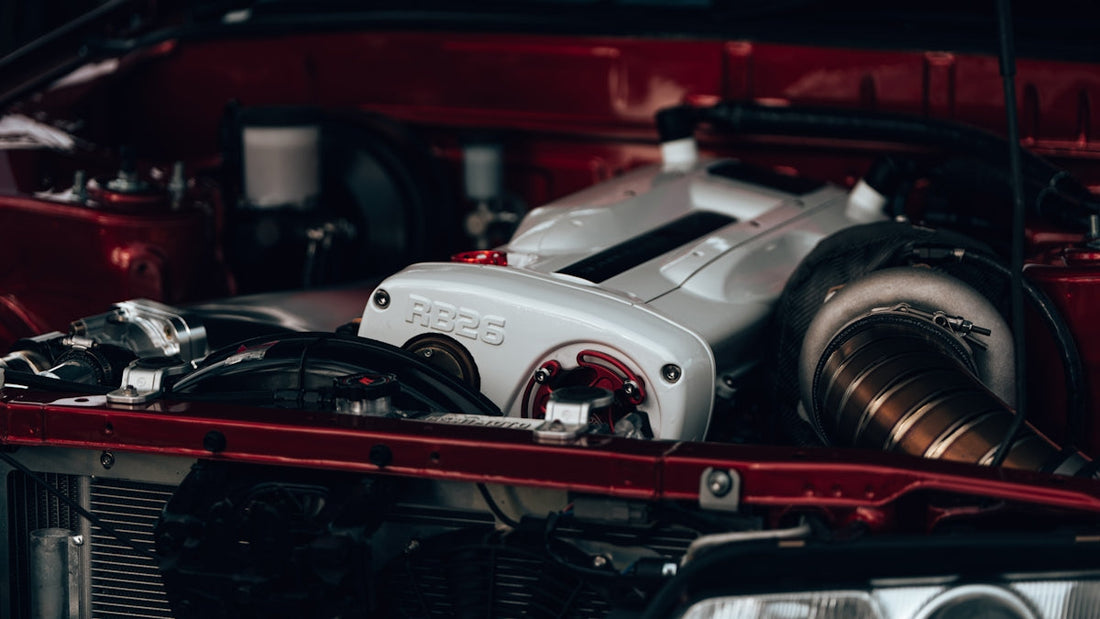 Close-up of a Nissan RB26 engine with turbocharger in a red engine bay