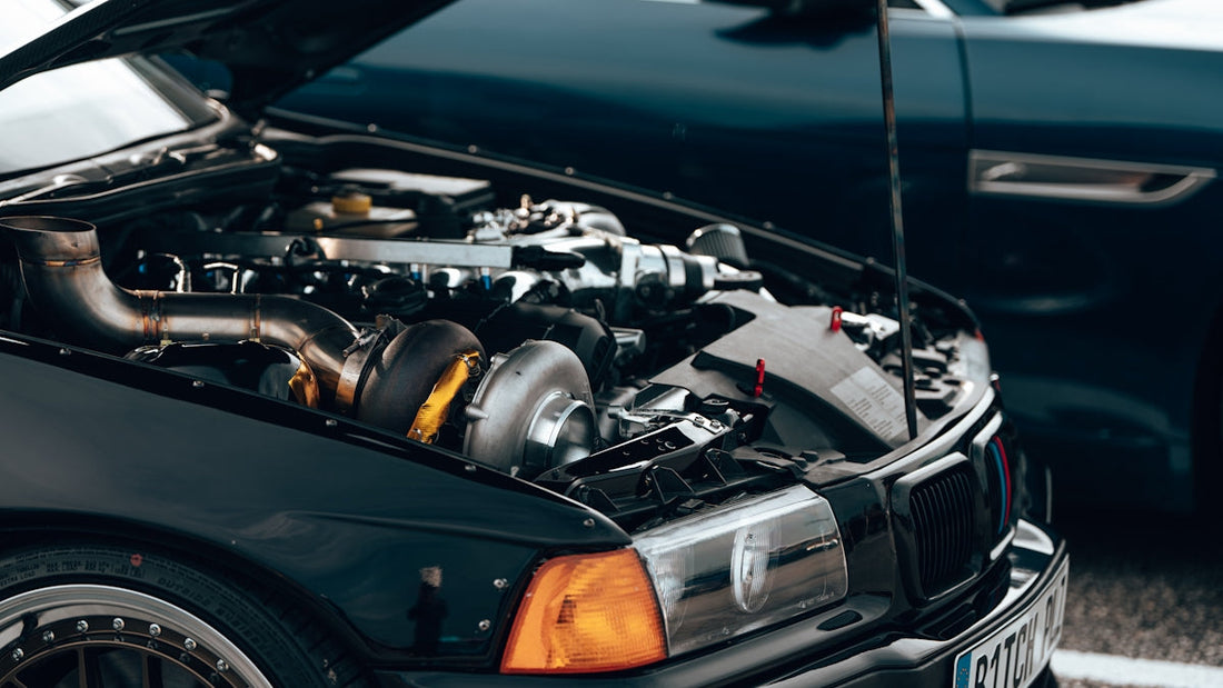 Close-up of a high-performance car engine with turbocharger under open hood at a car meet