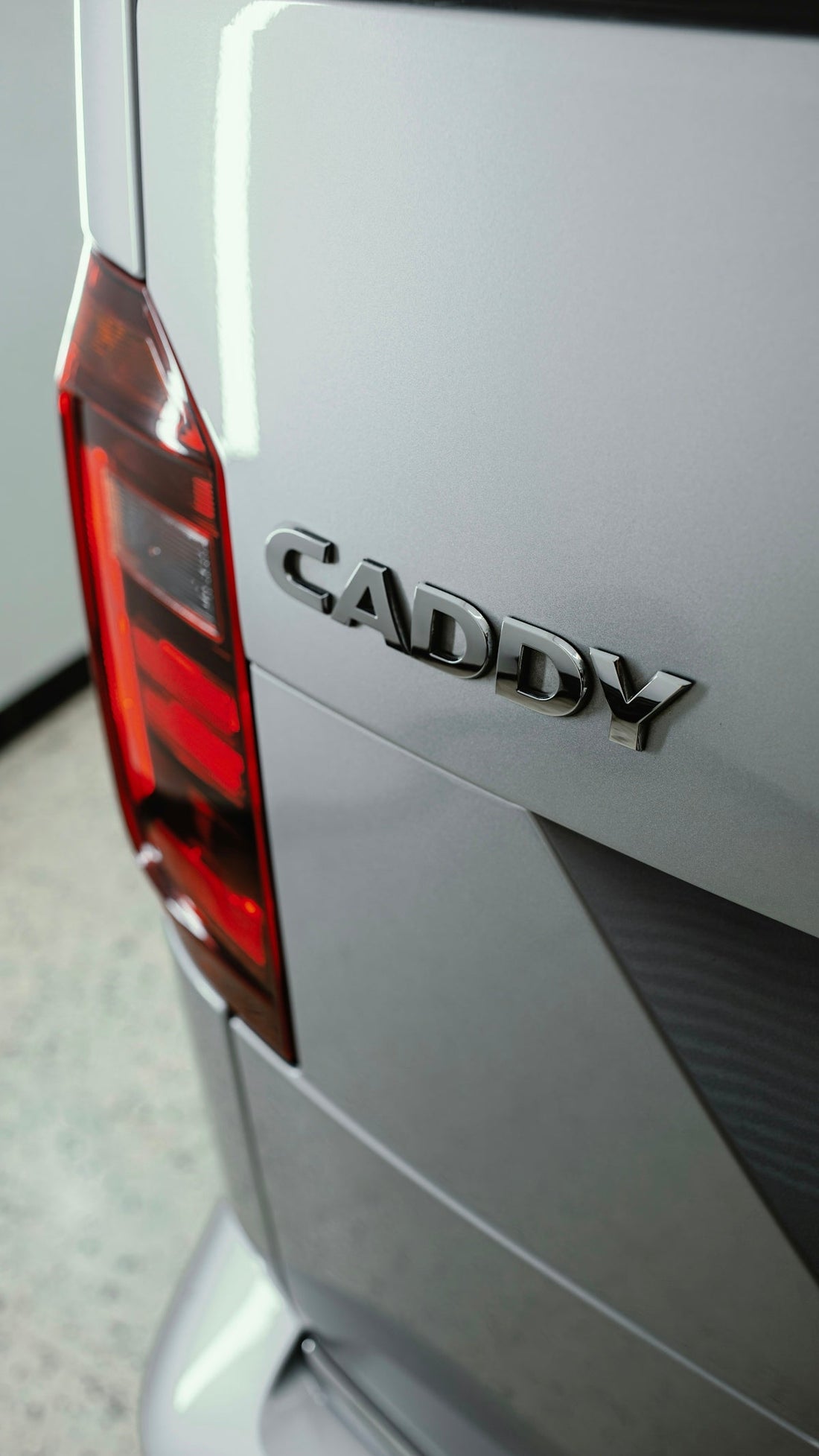 Close-up of silver Volkswagen Caddy rear with taillight and model badge