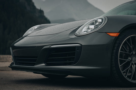 A grey porsche parked on the side of the road