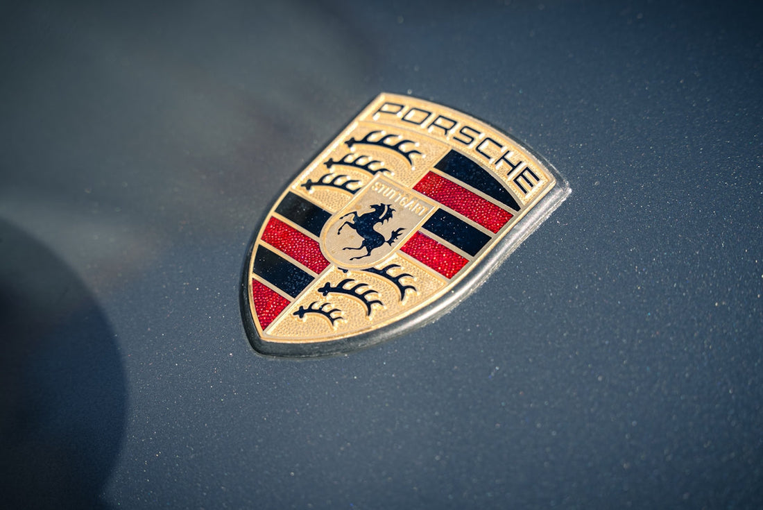Porsche emblem close-up on metallic gray exotic car hood