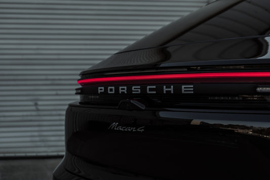 A black porsche parked in front of a garage