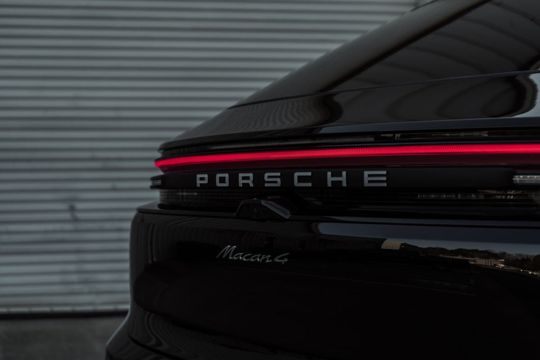 Rear view of black Porsche Macan G with LED tail light and model badge in focus