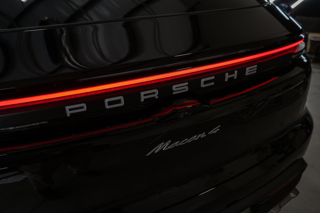 The back end of a porsche car parked in a garage