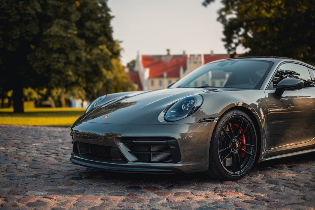 A sleek porsche parked in a beautiful location.