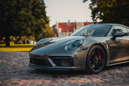 A sleek porsche parked in a beautiful location.