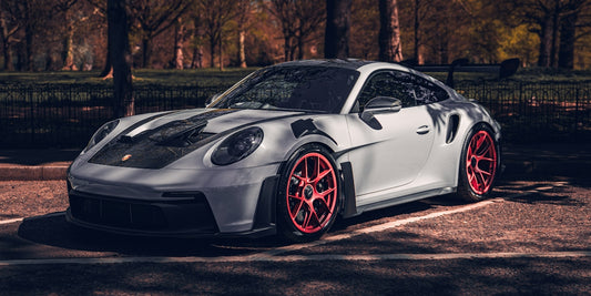A sleek white porsche is parked outside