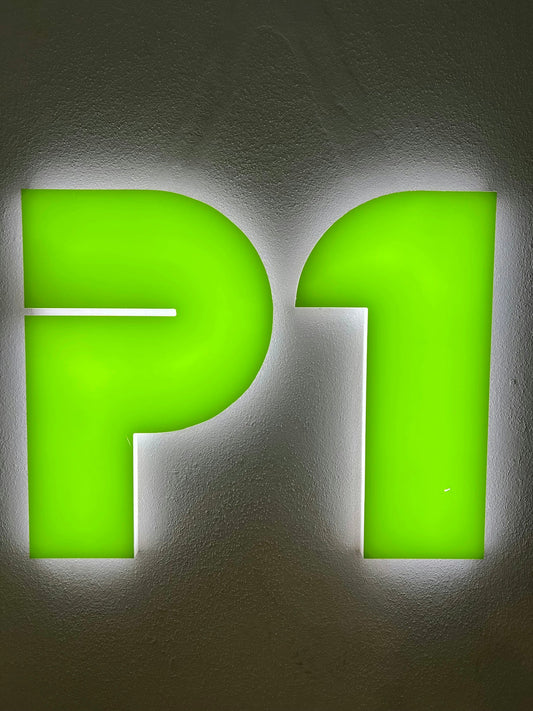 Bright green illuminated P1 sign on textured wall, automotive accessory keyword