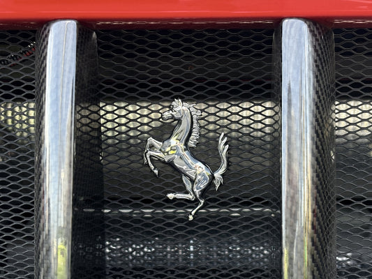A ferrari emblem on its car's grill.