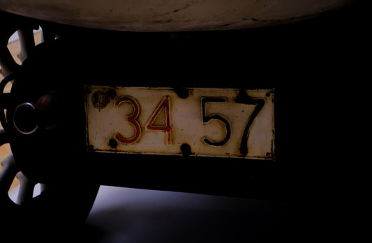 An old license plate displays the numbers 34.57.